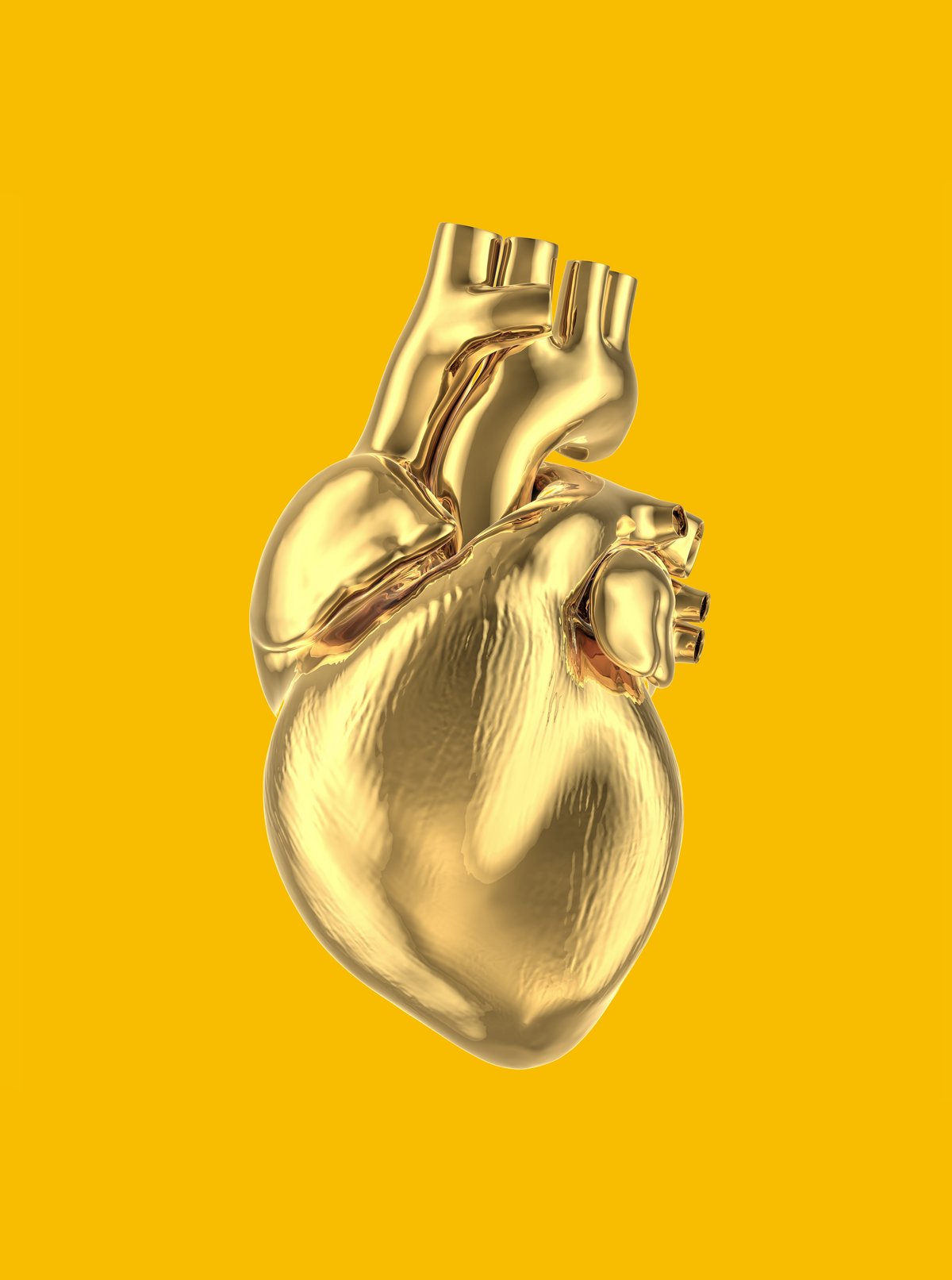 Goldenes, anatomisches Herz auf gelbem Hintergrund